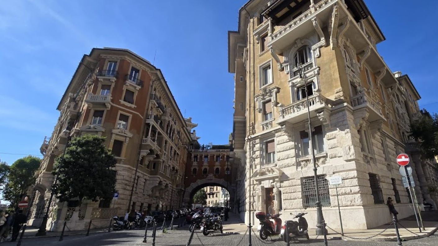 Palazzi decorati con arco sullo sfondo nel Quartiere Coppedè a Roma, rappresentativi dello stile architettonico eclettico della zona.