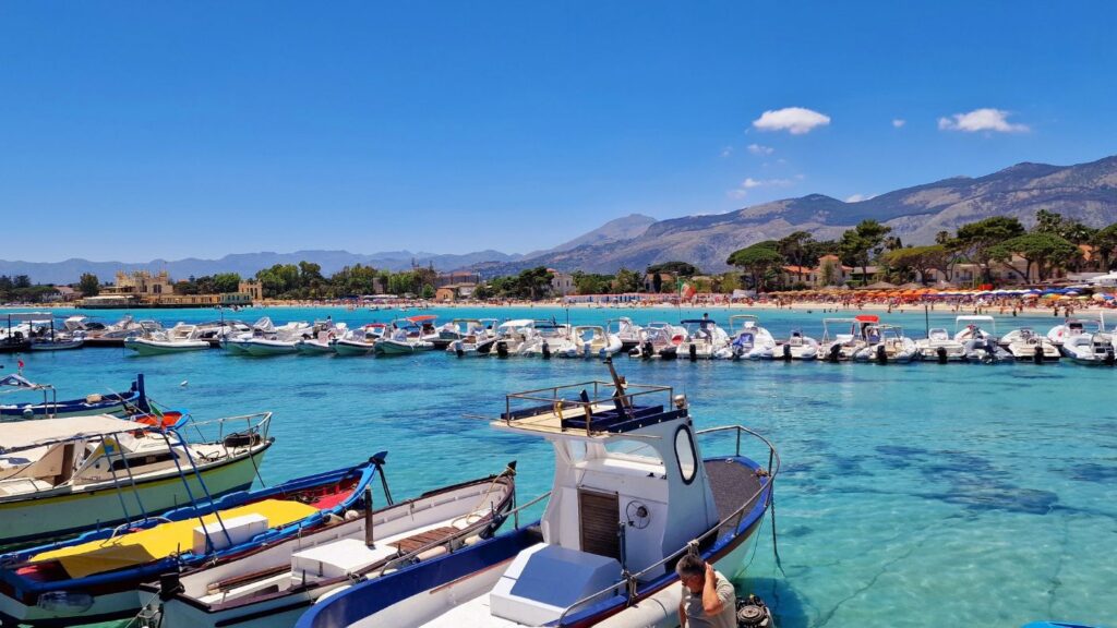 Vista di mare azzurro con barche in Sicilia a Mondello.