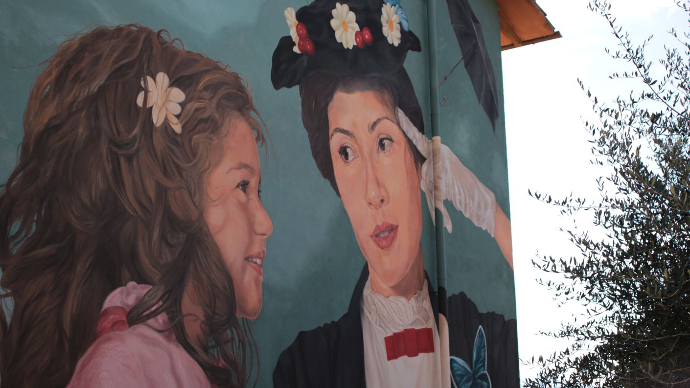 Murale di Mary Poppins con una bambina sulla facciata di un edificio a Sant'Angelo di Roccalvecce, il Paese delle Fiabe in provincia di Viterbo.