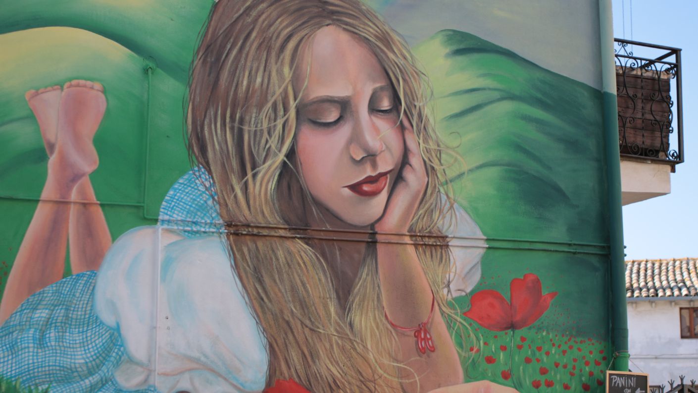 Murale di una ragazza che coglie tulipani, parte del percorso artistico nel Paese delle Fiabe a Sant'Angelo di Roccalvecce, in provincia di Viterbo.