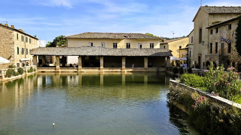 Vasca di Bagno Vignoni con loggiato sullo sfondo.