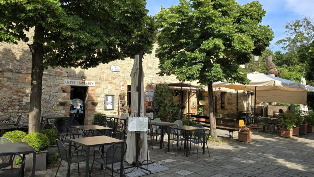 Tavolini all'aperto davanti alla Bottega del Cacio nel centro storico di Bagno Vignoni