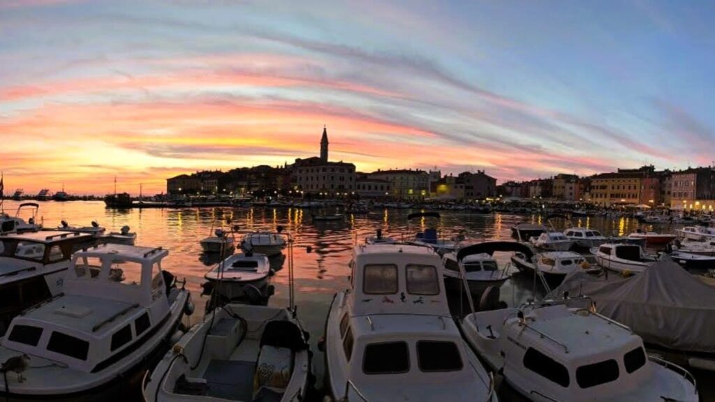 Veduta del centro di Rovigno in Croazia, con mare e barche al porto.