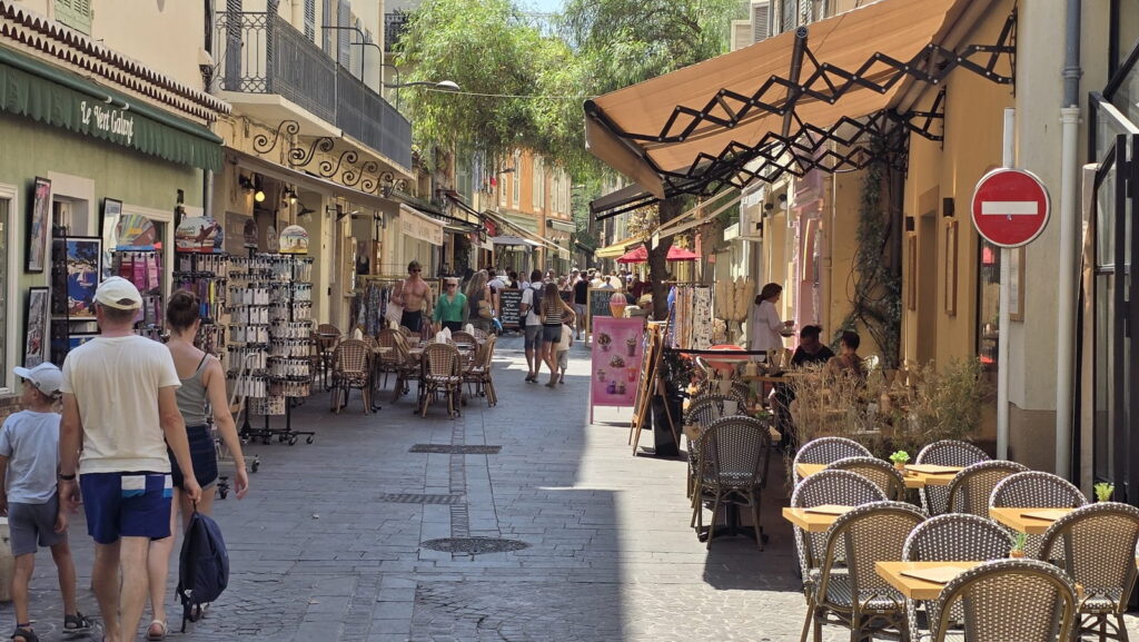 Strada di Antibes con negozi, ristoranti e persone per articolo Cosa vedere in un giorno ad Antibes