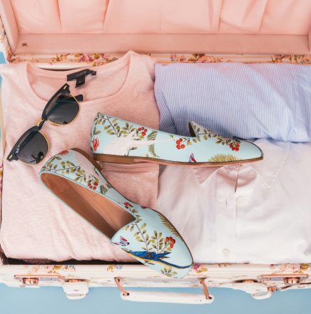 Valigia aperta con abiti e accessori pronti per un viaggio